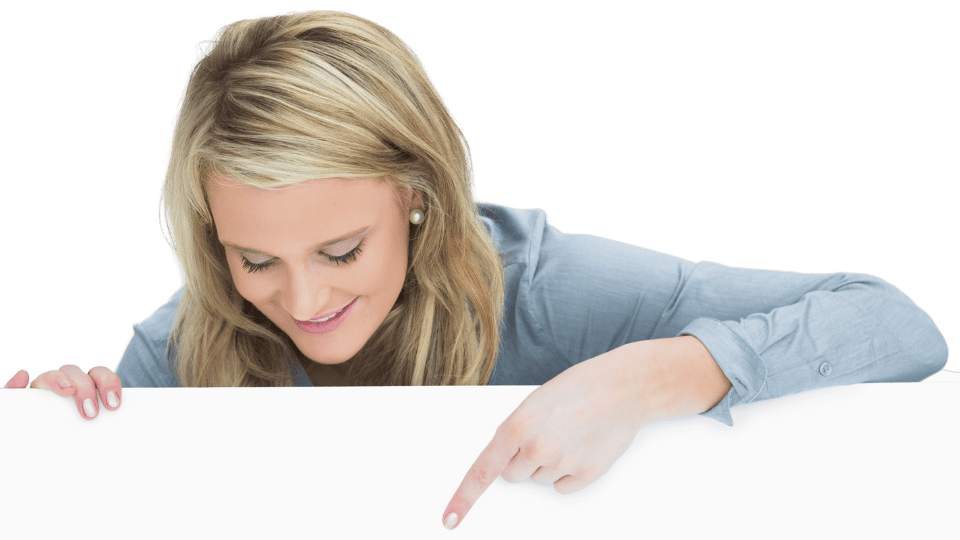 A woman with blonde hair wearing a light blue shirt looks down and points at a blank white space in front of her.